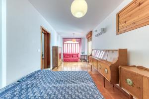 1 dormitorio con 1 cama, vestidor y silla roja en Casa Maddalena en Diso