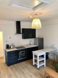 een keuken met zwarte kasten en een wit aanrecht bij A perfectly located bright, modern ,Victorian flat in Royal Tunbridge Wells