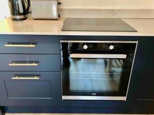 een keuken met een zwarte oven bij A perfectly located bright, modern ,Victorian flat in Royal Tunbridge Wells