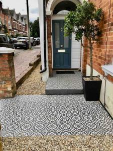 a house with a blue door and a potted tree at A perfectly located bright, modern ,Victorian flat in Royal Tunbridge Wells