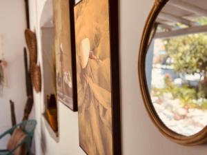 a mirror hanging on a wall with paintings at Casa Rico Frade Garden in São Pedro do Corval