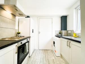 a kitchen with white cabinets and black counter tops at Convenient Shared Living Near City Center in Liverpool