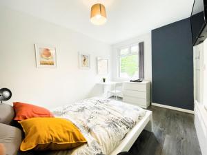 a bedroom with a bed and a desk and a window at Convenient Shared Living Near City Center in Liverpool