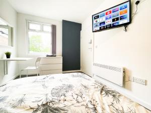 1 dormitorio con 1 cama y TV de pantalla plana en la pared en Convenient Shared Living Near City Center en Liverpool