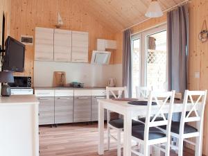 a kitchen with a white table and chairs at Holiday house near the sea in Pobierowo for 4 people in Pobierowo