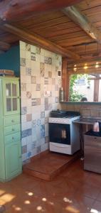 a kitchen with a stove and a tiled wall at Ára apart in Puerto Iguazú
