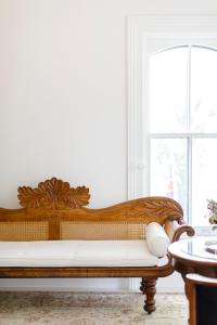 a wooden bench sitting in a room with a window at Woodbourne Inn in Niagara-on-the-Lake