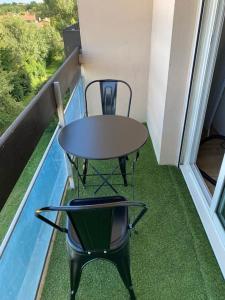 un tavolo e una sedia sul balcone con vista di Ramonville parking netflix a Ramonville-Saint-Agne