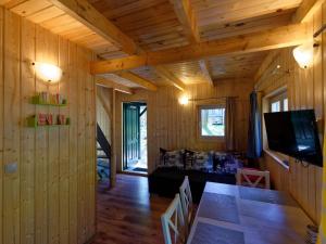 a room with wooden walls and a table and a tv at Holiday house in Pobierowo for 5 people near the sea in Pobierowo