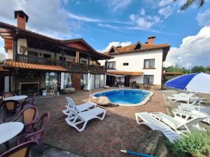 uma villa com uma piscina e mobiliário de pátio em Къща за гости Бащин дом em Apriltsi