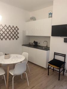 een keuken met een tafel en stoelen en een tafel en een wastafel bij DormiTrieste City Life Apartment in Trieste