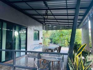 a screened in porch with a table and chairs at Ban Aob Maiy(บ้านโอบไม้) in Ban Si Wicha