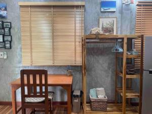 Zimmer mit einem Schreibtisch, einem Tisch und einem Stuhl in der Unterkunft Ban Aob Maiy(บ้านโอบไม้) in Ban Si Wicha