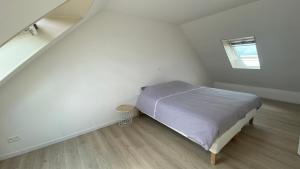 Habitación blanca pequeña con cama y ventana en L’apparté, meublé de tourisme en Saint-Folquin