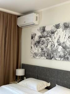 1 dormitorio con 1 cama y una pintura en la pared en Yes apartments en Astaná