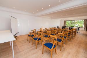 a room with rows of chairs and a white wall at Petit Garden Hotel by Flacalco in Cala Ratjada