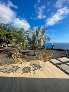 3 chaises et une table sur une terrasse donnant sur l'océan dans l'établissement Casa El Guinche, à Fuencaliente de la Palma
