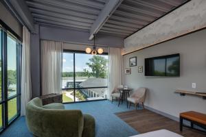 uma sala de estar com um sofá e cadeiras e uma televisão em voco James Newbury Hudson Valley, an IHG Hotel em Coxsackie