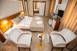 a hotel room with a bed and two chairs and a table at Afyon MCG Marble Hotel in Afyon