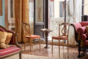 Habitación con sillas, mesa y chimenea en Imperiale Piano Nobile en Venecia