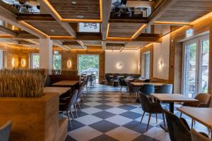 a restaurant with wooden ceilings and tables and chairs at Hotel INA in Borşa
