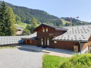 un grupo de edificios con una montaña en el fondo en Demi-Chalet Le Bief --Prox pistes, en Les Carroz d'Araches