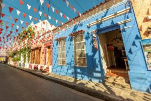 un edificio azul con toldo al lado de una calle en CASA EL CAMINANTE En Getsemani, en Cartagena de Indias