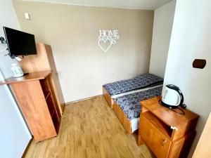 a small room with a bed and a desk and a tv at Promyk in Władysławowo