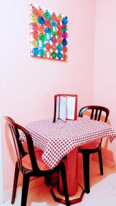 uma mesa com duas cadeiras e uma toalha de mesa xadrez vermelha e branca em Lips Motel (Adult Only) no Rio de Janeiro