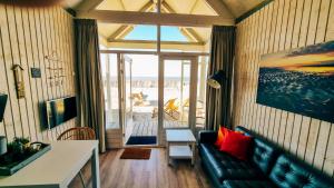 a living room with a couch and a view of the ocean at Kusthuisjes.nl in Katwijk