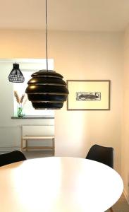 ein Esszimmer mit einem Tisch und einer Hängeleuchte in der Unterkunft Idyllic Suite in the Heart of Tammisaari in Tammisaari