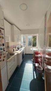 uma cozinha com armários brancos e pisos em azulejo azul em Charming apartment in Lisbon em Lisboa