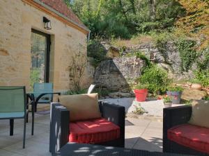 een patio met 2 stoelen en een tafel bij La P'tite Maison in Carlux