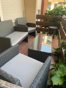 a patio with chairs and tables on a balcony at Piso Attila in Sanxenxo
