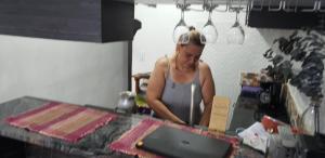 a woman standing behind a counter in a kitchen at Aparta-estudios Alf in Cali