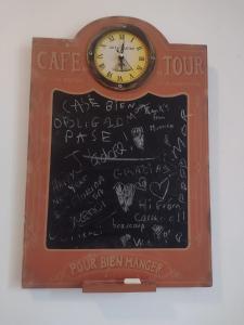 un panneau de craie avec une horloge au dessus dans l'établissement Chez Ma Petite Reine 1, à Pontoise