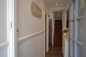 a hallway of a house with a sign on the wall at Relax Inn Guest House in Brighton & Hove