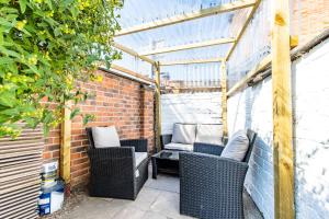 a patio with two wicker chairs in a greenhouse at Warburton House, Newark - Walking distance from North Gate Train Station & Market Place in Newark upon Trent