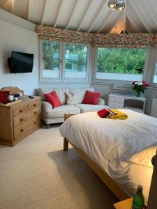 um quarto com uma cama e um sofá em Brookfield Cottage em West Kirby