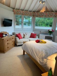 a bedroom with a bed and a couch at Brookfield Cottage in West Kirby