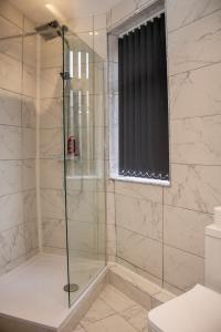 a shower with a glass door in a bathroom at Pleasant City Escape in Aintree