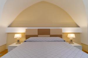 a bedroom with a large bed with two lamps at La rimesa di Tittì - Anna in Alezio