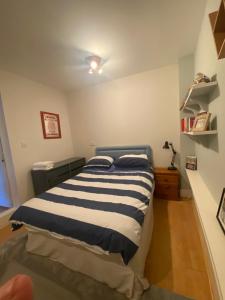a bedroom with a bed with a blue and white blanket at Two double bedrooms in Paddock Wood in Paddock Wood
