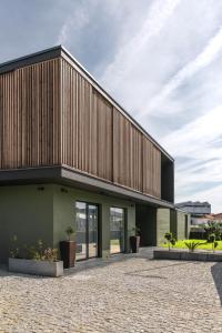 a building with a wooden facade with potted plants at Geonature in Macedo de Cavaleiros