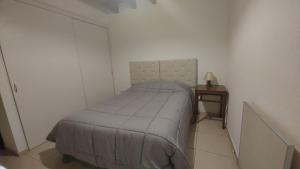 een kleine slaapkamer met een bed en een bijzettafel bij DEPARTAMENTO RENATO in Godoy Cruz
