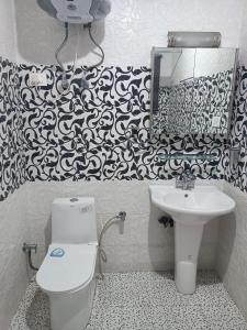 y baño con aseo y lavamanos. en Coachman HomeStay, en Srinagar