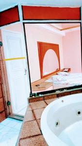 uma casa de banho com banheira e uma cama num quarto em Lips Motel (Adult Only) no Rio de Janeiro
