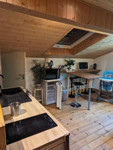 uma cozinha com pisos de madeira e um tecto de madeira em Gîte zen dans les bois em Blésignac