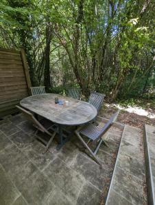 een tafel en 2 stoelen op een patio bij Gîte zen dans les bois in Blésignac