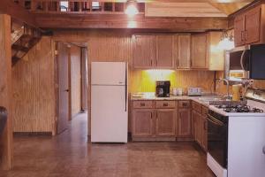 eine Küche mit einem weißen Kühlschrank und Holzschränken in der Unterkunft Family Fishing Stay - Private Cahaba River Access 